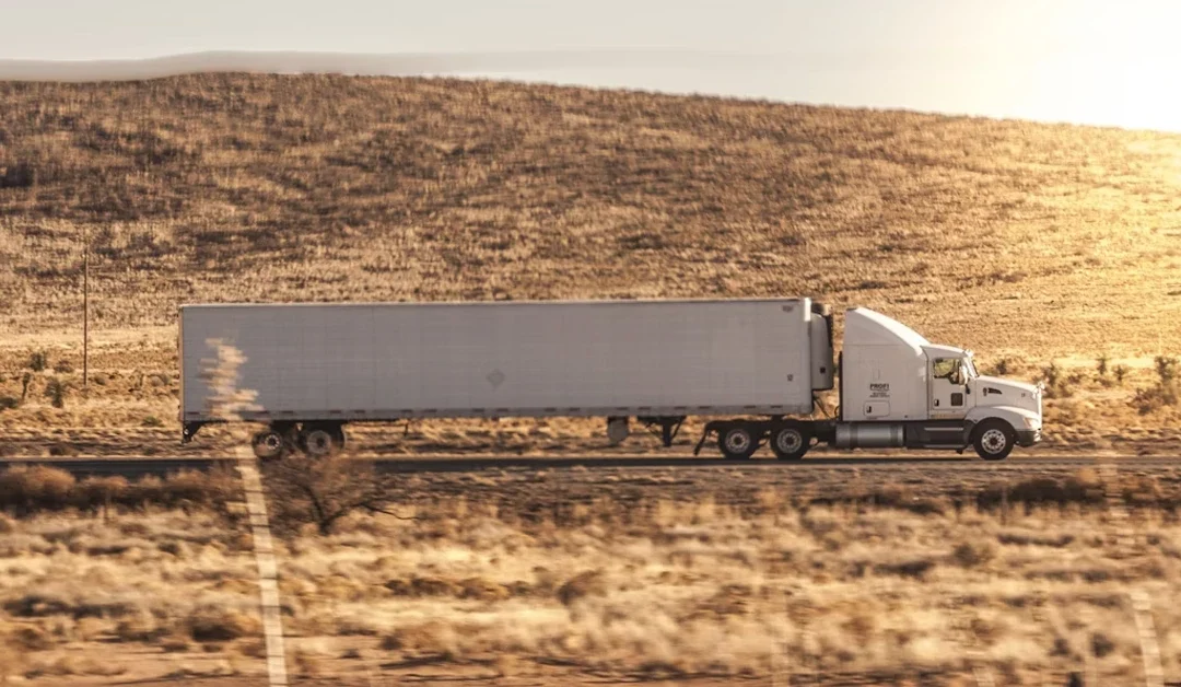 Large moving truck driving across a Texas highway under the open sky, symbolizing trusted long-distance moving services At Matthew and Mois