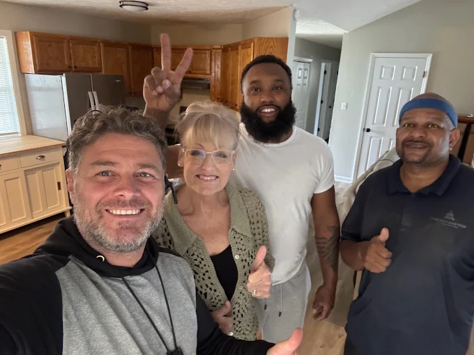 One of the Matthew and Mois crew taking a selfie with a customer and two other movers in a kitchen